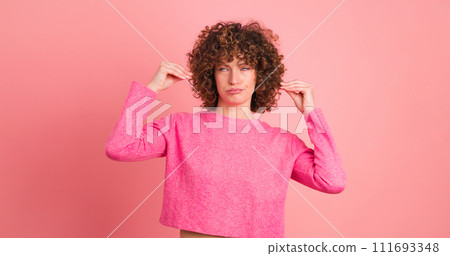 Bored young woman saying blah blah with hands gesture on pink background Bored young woman saying blah blah with hands gesture on pink background 111693348
