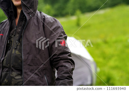 Kyiv, Ukraine, - Jule 12, 2023 Mammut technology and water drops. A man in a waterproof jacket. In a jacket in the rain. 111693940