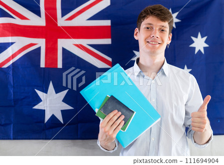Young guy posing with documents against background of Australian flag Young guy posing with documents against background of Australian flag 111694904