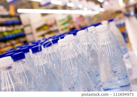 Water bottles with blue caps in supermarket 111694973