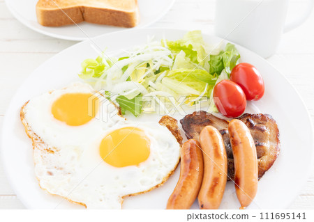 Delicious fried egg, sausage, bacon and vegetable salad for breakfast 111695141