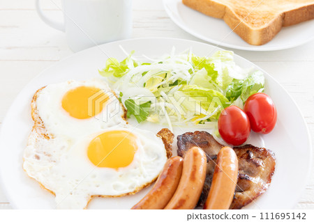 Delicious fried egg, sausage, bacon and vegetable salad for breakfast Delicious fried egg, sausage, bacon and vegetable salad for breakfast 111695142