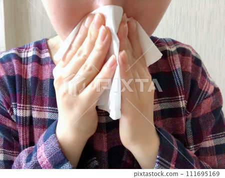 Woman blowing her nose Woman blowing her nose 111695169