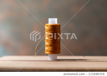 Tattoo with beige thread. Thread on the table. Tattoo with beige thread. Thread on the table. 111696358