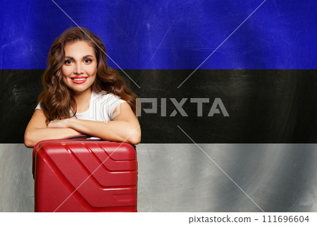 Love Estonia. Smiling woman with red suitcase on Estonian flag background. 111696604