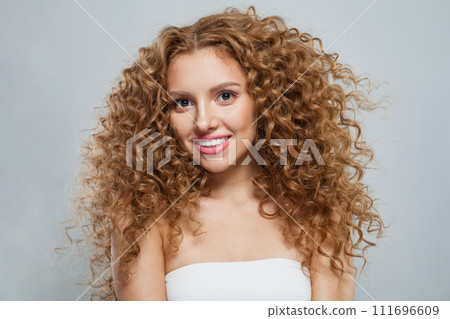 Joyful redhead female model with long frizzy ginger hair and clean soft fresh skin posing 111696609