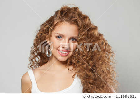 Friendly redhead female model with long frizzy ginger hair and clean soft fresh skin posing  111696622