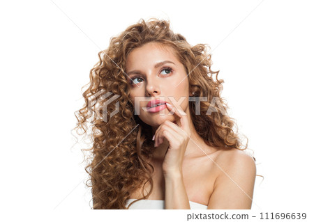 Thinking redhead female model with long frizzy ginger hair and clean soft fresh skin posing  111696639