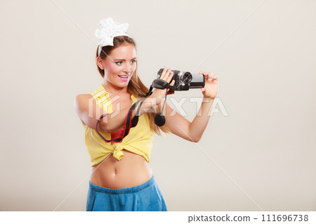 Happy pin up girl woman filming with camcorder. 111696738