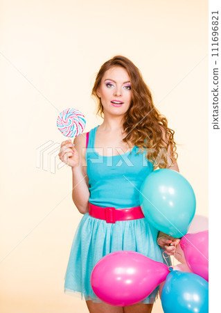 Woman with colorful balloons and lollipop 111696821