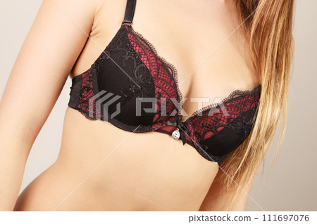 Woman in black bra lingerie taking care of her breasts 111697076