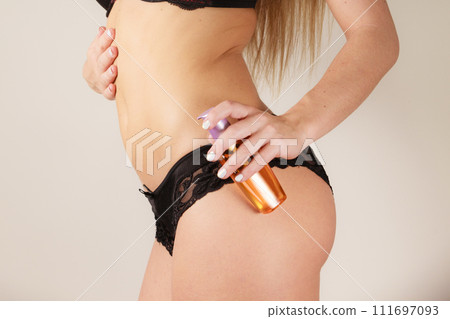 Woman applying moisturizing body oil lotion 111697093