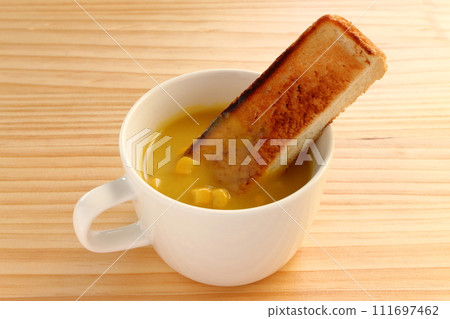 Grain corn soup and toast in a cup on the table Grain corn soup and toast in a cup on the table 111697462