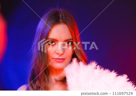 Woman holding carnival feather fan in hand. 111697529