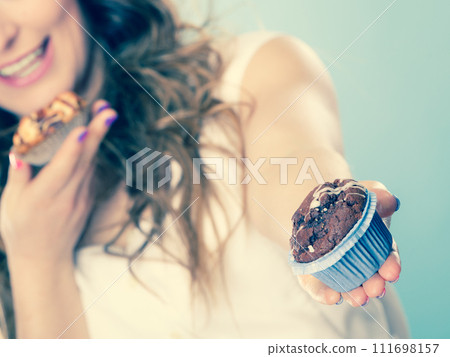 Smiling summer woman holds cakes in hand Smiling summer woman holds cakes in hand 111698157