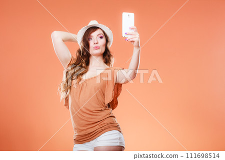 Woman taking self picture with smartphone camera 111698514