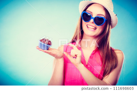 Smiling summer woman holds cake in hand Smiling summer woman holds cake in hand 111698603