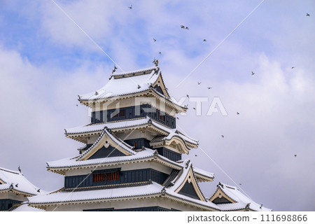 National treasure Matsumoto Castle, large castle tower with pigeons flying around [winter] 111698866
