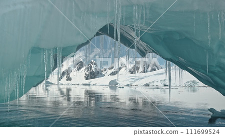 Glacier arch at ocean bay seascape aerial. Environment issue of melting iceberg and global warming. Climate change of polar nature. Ecology problem of ice and snow melting of South Pole drone shot 111699524