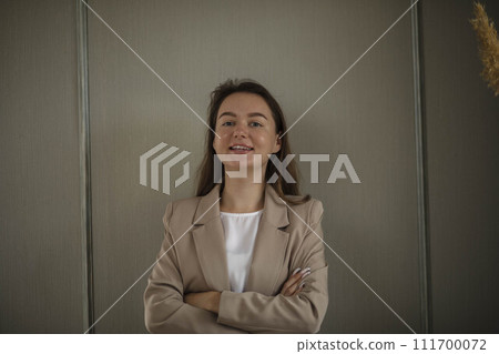 Happy Businesswoman in Office. Stylish Beautiful Manager Smiling It stands against green wall, Working on Financial and Marketing Projects Happy Businesswoman in Office. Stylish Beautiful Manager Smiling It stands against green wall, Working on Financial and Marketing Projects 111700072