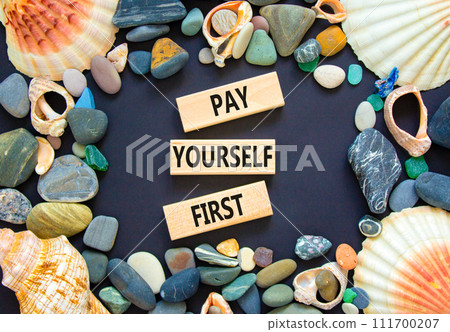 Pay yourself first symbol. Concept words Pay yourself first on beautiful wooden blocks. Beautiful black table black background. Sea shell stone. Business and pay yourself first concept. Copy space. Pay yourself first symbol. Concept words Pay yourself first on beautiful wooden blocks. Beautiful black table black background. Sea shell stone. Business and pay yourself first concept. Copy space. 111700207