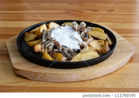 Potato dish with mushrooms on wooden table Potato dish with mushrooms on wooden table 111700595