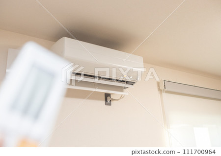 操作空調器的遙控的男性手 操作空調器的遙控的男性手 111700964