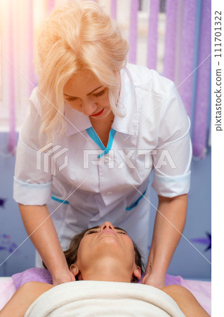 Masseur woman massages her shoulders. Woman getting a massage at the spa Masseur woman massages her shoulders. Woman getting a massage at the spa 111701322