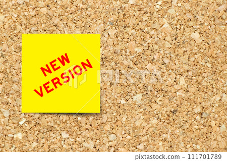 Yellow note paper with word new version on cork board background with copy space Yellow note paper with word new version on cork board background with copy space 111701789