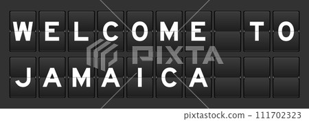 Black color analog flip board with word welcome to jamaica on gray background 111702323