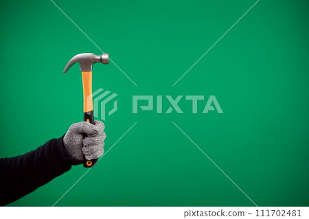man's hand holding a hammer on a plain background. High quality photo man's hand holding a hammer on a plain background. High quality photo 111702481