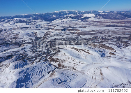 Aerial view of snow covered countryside hills and meadow Aerial view of snow covered countryside hills and meadow 111702492