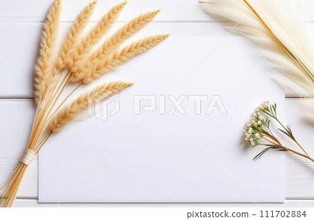 Blank empty cardstock sheet Invitation without text, invitation mockup. Dry pampas, flowers, white desk. Flat lay, top view. Soft paper card floral mock up. Modern Minimal business brand template. A4 111702884