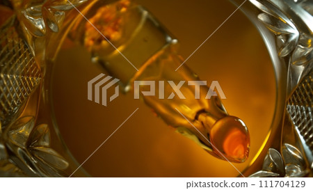 Freeze Motion Shot of Whiskey Liquid Pouring, Macro, Unique Angle of View from the Bottom of the Glass Freeze Motion Shot of Whiskey Liquid Pouring, Macro, Unique Angle of View from the Bottom of the Glass 111704129