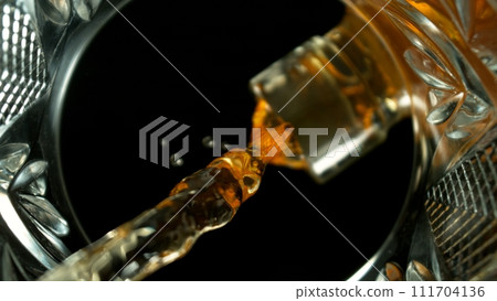 Freeze Motion Shot of Whiskey Liquid Pouring, Macro, Unique Angle of View from the Bottom of the Glass Freeze Motion Shot of Whiskey Liquid Pouring, Macro, Unique Angle of View from the Bottom of the Glass 111704136