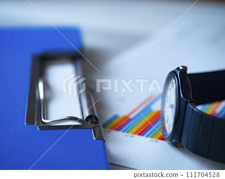 Graphs, binders, and watches on the table Graphs, binders, and watches on the table 111704528