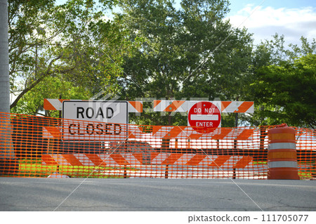 Yellow protective fence barrier at street construction site. Warning road sign about utility work Yellow protective fence barrier at street construction site. Warning road sign about utility work 111705077