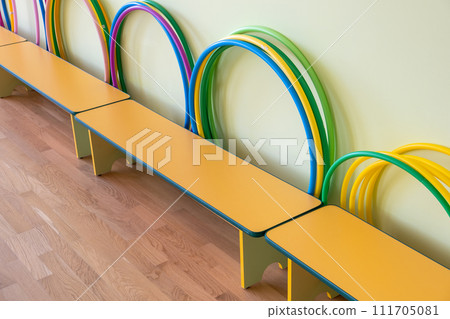 Yellow benches inside a school sports gym. 111705081