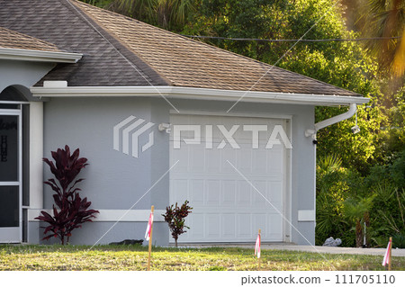 Wide garage double door and concrete driveway of new modern american house Wide garage double door and concrete driveway of new modern american house 111705110