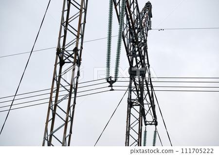 Steel pillar with high voltage electric power lines delivering electrical energy through cable wires on long distance Steel pillar with high voltage electric power lines delivering electrical energy through cable wires on long distance 111705222