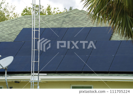 Standard american residential house with rooftop covered with solar photovoltaic panels for producing of clean ecological electrical energy in suburban rural area. Concept of autonomous home Standard american residential house with rooftop covered with solar photovoltaic panels for producing of clean ecological electrical energy in suburban rural area. Concept of autonomous home 111705224