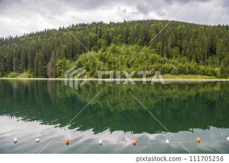 Rope with white and yellow restriction markers on water surface for prohibiting of swimming in deep lake or sea. 111705258