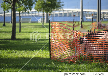 Restriction plastic mesh fence at industrial construction site. Protective barrier for pedestrians safety 111705285