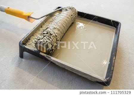 Paint roller in paint tray with grey color in the tray Paint roller in paint tray with grey color in the tray 111705329