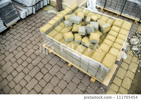 Installation of stone paving slabs in a yard. Installation of stone paving slabs in a yard. 111705454