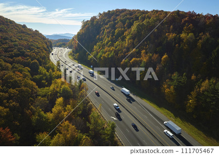 I-40 freeway road leading to Asheville in North Carolina over Appalachian mountain pass with yellow fall forest and fast moving trucks and cars. Concept of high speed interstate transportation 111705467