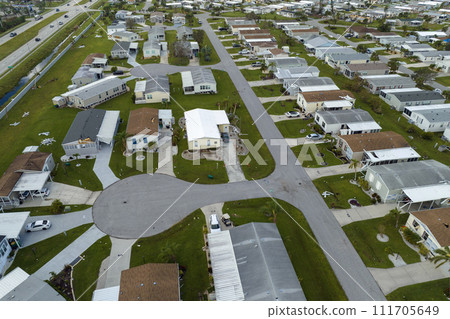 Consequences of natural disaster in southern Florida after hurricane season. Severely damaged houses in mobile home residential area Consequences of natural disaster in southern Florida after hurricane season. Severely damaged houses in mobile home residential area 111705649