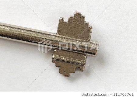 Close-up detail of old well-used steel key isolated on white copy space background. Safety and security concept. Close-up detail of old well-used steel key isolated on white copy space background. Safety and security concept. 111705761