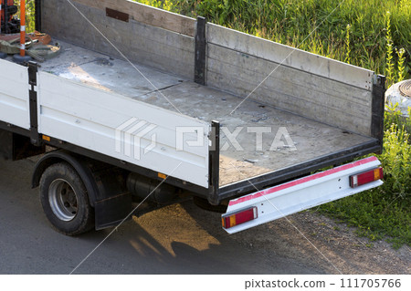 Close-up detail of empty hydraulic truck mounted crane body parked on green grassy roadside. Modern advanced transportation vehicles construction, goods delivery, loading and unloading concept. 111705766