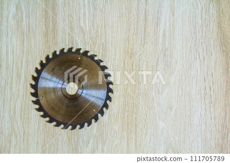 Close up of circular saw blade for wood work on wooden background. Top view. Close up of circular saw blade for wood work on wooden background. Top view. 111705789
